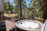 Relax and unwind in this stunning mountain retreat, featuring a spacious deck with a bubbling hot tub perfect for soaking up the scenic views.