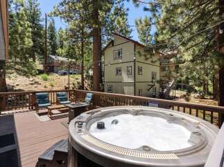 Relax and unwind in this stunning mountain retreat, featuring a spacious deck with a bubbling hot tub perfect for soaking up the scenic views.