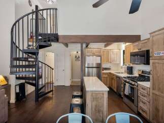 Discover this charming home featuring a stunning spiral staircase leading to an upper level, perfect for maximizing space.