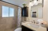 This beautifully updated bathroom features a spacious walk-in shower with elegant tile work and a frosted window for privacy.
