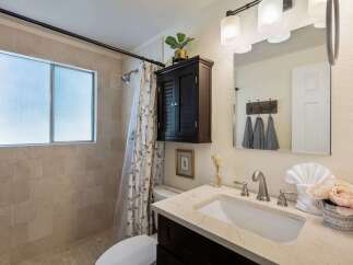 This beautifully updated bathroom features a spacious walk-in shower with elegant tile work and a frosted window for privacy.