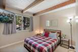 Experience cozy mountain living in this charming bedroom featuring a comfortable bed with a classic plaid comforter.