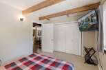 Experience cozy comfort in this charming bedroom featuring a striking red, white, and gray plaid comforter on the bed.
