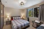 Experience cozy comfort in this charming bedroom featuring a plaid comforter and matching pillows, perfect for a restful night's sleep.