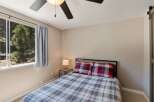This cozy bedroom features a comfortable bed dressed in a charming plaid comforter and matching pillows.