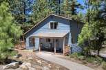 Nestled amidst tall pine trees, this charming blue home offers a serene mountain retreat.