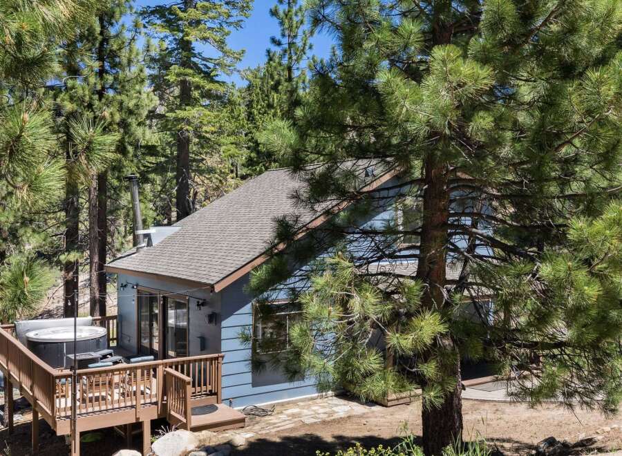 Escape to this charming cabin nestled among tall pine trees, offering a private hot tub on the deck for ultimate relaxation.