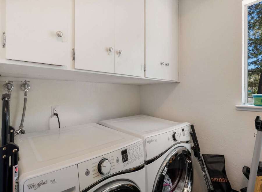 This laundry room features a stacked Whirlpool Duet washer and dryer set, perfect for maximizing space.