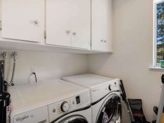 This laundry room features a stacked Whirlpool Duet washer and dryer set, perfect for maximizing space.