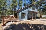 Escape to this charming blue cabin nestled among tall pine trees, offering a serene mountain retreat.