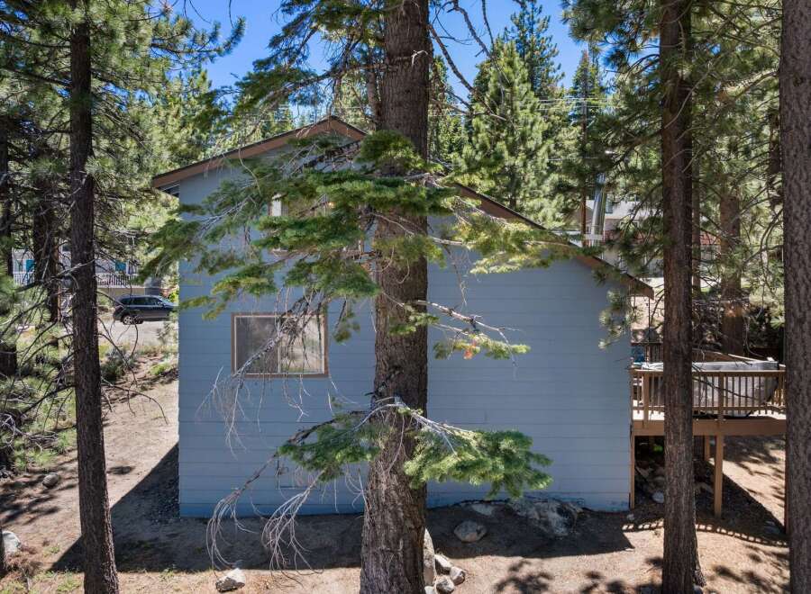 Nestled amongst tall pine trees, this charming home offers a serene mountain retreat.