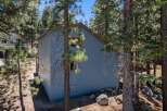 Nestled amidst tall pine trees, this charming blue home offers a serene mountain retreat.