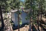 Nestled amongst tall pine trees, this charming blue home offers a serene mountain retreat.