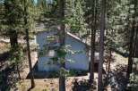 Nestled amongst tall pine trees, this charming home offers a serene mountain retreat.