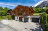 Experience alpine living in this stunning wooden chalet, nestled against a backdrop of majestic snow-capped mountains.