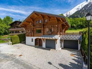 Experience alpine living in this stunning wooden chalet, nestled against a backdrop of majestic snow-capped mountains.