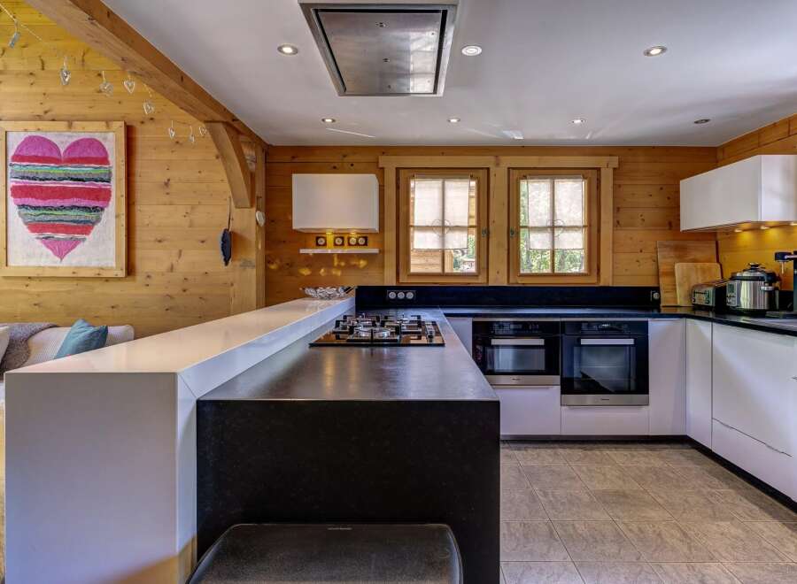 Experience rustic charm and modern convenience in this beautifully appointed kitchen, featuring warm wood paneling and a sleek, contemporary island.