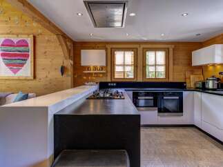 Experience rustic charm and modern convenience in this beautifully appointed kitchen, featuring warm wood paneling and a sleek, contemporary island.