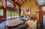 Experience the ultimate mountain retreat in this stunning chalet living room, featuring a vaulted wooden ceiling and expansive windows that frame breathtaking alpine views.