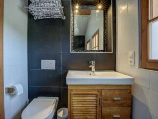 This modern bathroom features a sleek vanity with ample storage, a pristine white sink, and a chrome faucet.
