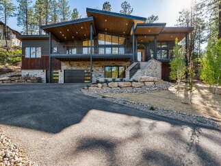 Experience modern mountain living in this stunning architectural masterpiece, featuring a striking contemporary design with natural wood accents and expansive glass windows.