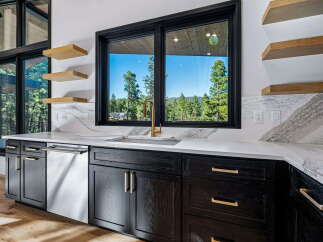 Experience modern luxury in this stunning kitchen, featuring sleek dark wood cabinetry with elegant gold hardware.
