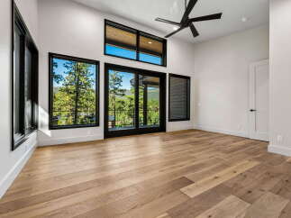 Experience breathtaking mountain views from this stunning modern bedroom, featuring expansive windows that flood the space with natural light.
