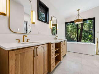 Experience luxury in this stunning bathroom, featuring a spacious double vanity with elegant gold fixtures and ample storage.