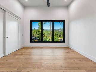 Experience breathtaking mountain views from this spacious room, featuring a large, multi-panel window that floods the space with natural light.