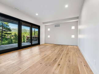 Experience breathtaking mountain views from this spacious room, featuring expansive sliding glass doors that seamlessly blend indoor and outdoor living.