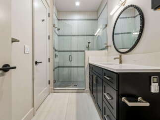 Experience modern luxury in this stunning bathroom featuring a spacious glass-enclosed shower with elegant tile work.
