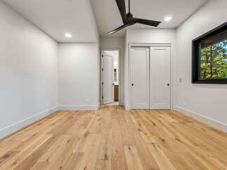 Experience modern living in this beautifully appointed bedroom featuring sleek white walls and a stunning hardwood floor.