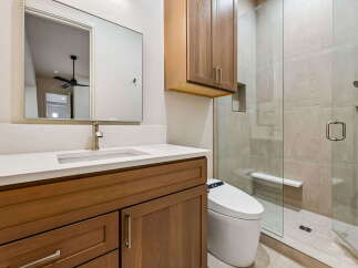 Experience modern luxury in this stunning bathroom featuring a sleek vanity with ample storage and a pristine quartz countertop.