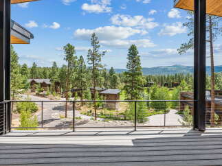 Experience luxury mountain living from this stunning property, featuring a spacious deck with panoramic views of the surrounding pine forest and rolling hills.