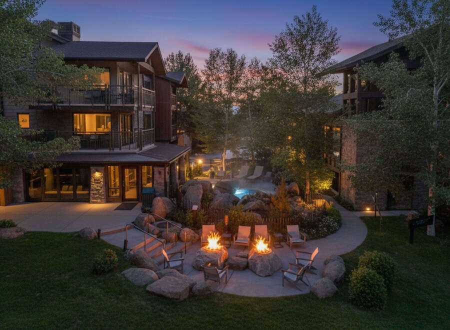 Experience luxury mountain living with this stunning property featuring multiple buildings, a serene outdoor pool, and inviting fire pits perfect for evening relaxation.