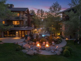 Experience luxury mountain living with this stunning property featuring multiple buildings, a serene outdoor pool, and inviting fire pits perfect for evening relaxation.
