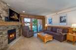 Cozy up by the stone fireplace in this inviting living room, perfect for relaxing after a day on the slopes.