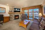 Cozy living room featuring a stone fireplace with a mounted TV and a comfortable recliner.