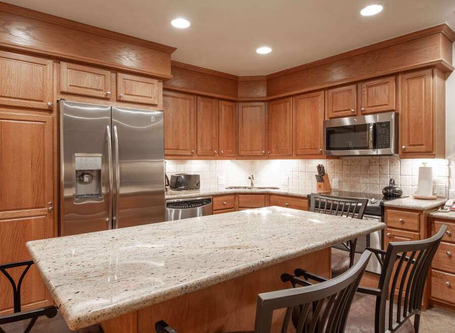 Experience culinary excellence in this beautifully appointed kitchen, featuring rich oak cabinetry and a stunning granite-topped island perfect for casual dining or entertaining.