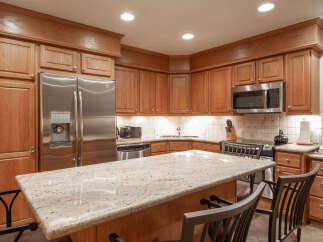 Experience culinary excellence in this beautifully appointed kitchen, featuring rich oak cabinetry and a stunning granite-topped island perfect for casual dining or entertaining.