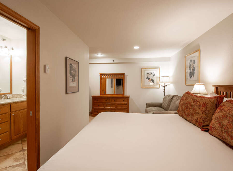 Experience comfort and style in this inviting hotel room, featuring a plush king-size bed adorned with decorative pillows.
