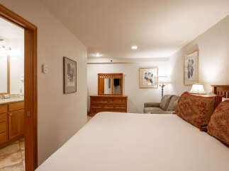 Experience comfort and style in this inviting hotel room, featuring a plush king-size bed adorned with decorative pillows.