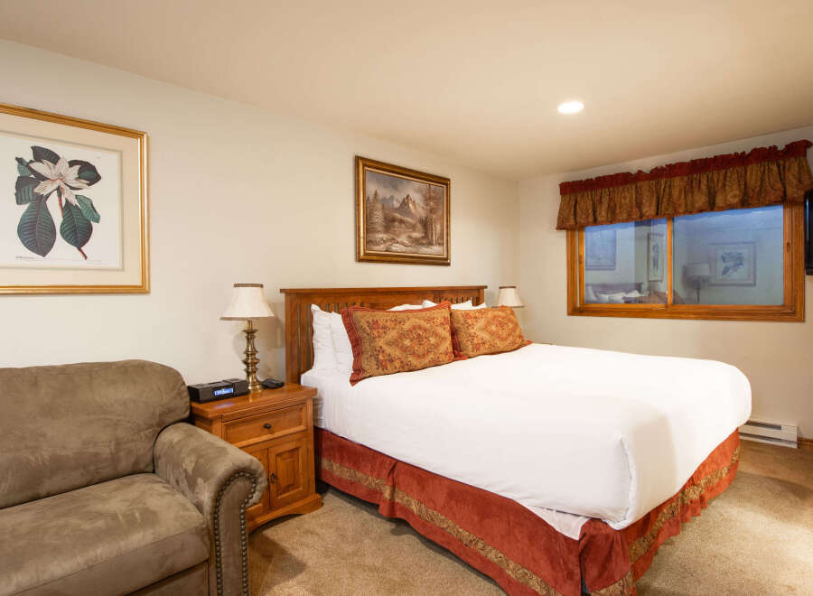 Experience comfort and style in this inviting bedroom, featuring a plush queen-size bed adorned with decorative pillows and crisp white linens.