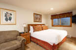 Experience comfort and style in this inviting bedroom, featuring a plush queen-size bed adorned with decorative pillows and crisp white linens.