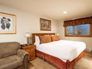 Experience comfort and style in this inviting bedroom, featuring a plush queen-size bed adorned with decorative pillows and crisp white linens.