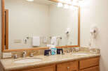 This spacious bathroom features a double vanity with granite countertops and modern chrome fixtures, perfect for any morning routine.
