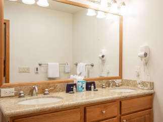 This spacious bathroom features a double vanity with granite countertops and modern chrome fixtures, perfect for any morning routine.