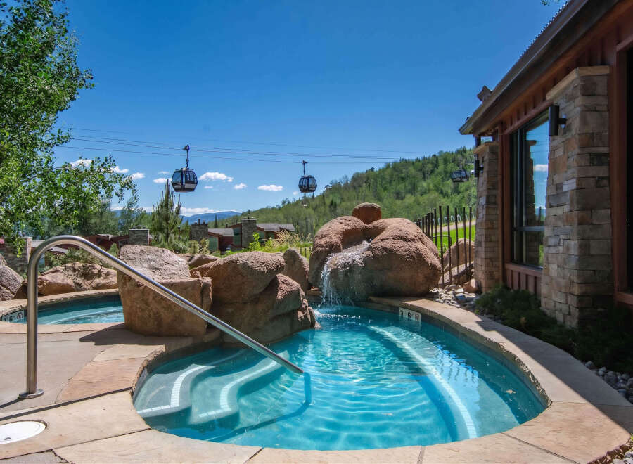 Experience ultimate relaxation in this stunning outdoor spa area, complete with a cascading waterfall feature and crystal-clear turquoise water.