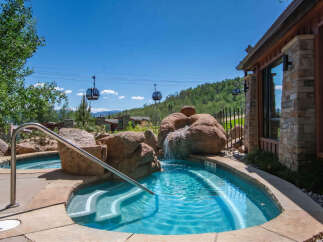 Experience ultimate relaxation in this stunning outdoor spa area, complete with a cascading waterfall feature and crystal-clear turquoise water.