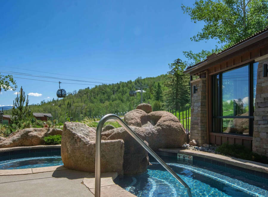 Experience luxury living with this stunning property featuring a private hot tub overlooking a scenic mountain landscape.